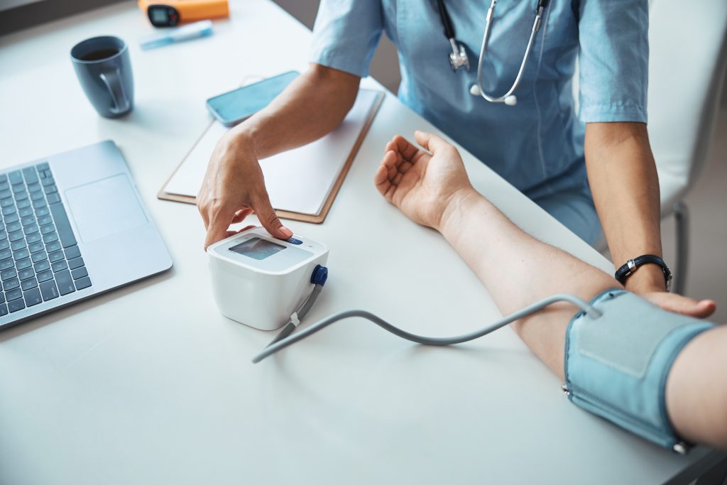 Female doctor checking patient blood pressure in clinic